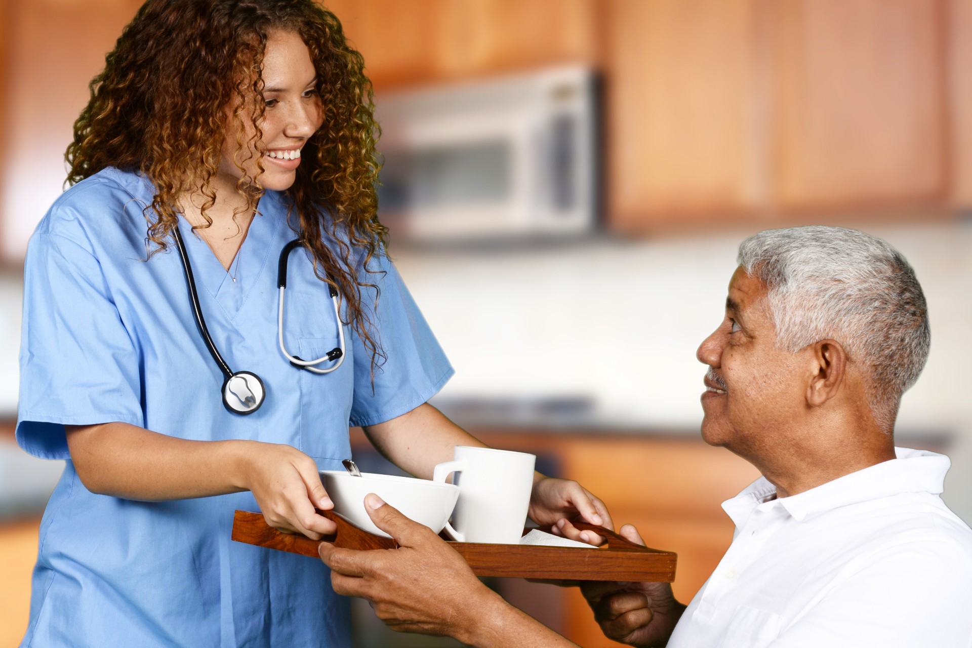 National Nursing and Rehab nurse serving food to elderly man