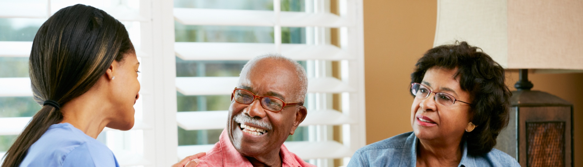 National Nursing and Rehab nurse taking notes during home visit with senior couple